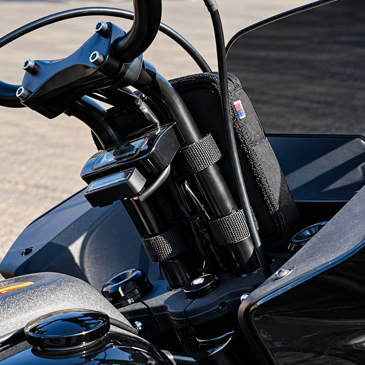 Black Moto Pockets Mini T-Bar motorcycle handlebar bag installed between tall handlebar risers, showing adjustable mounting straps and secure fit behind the handlebars.
